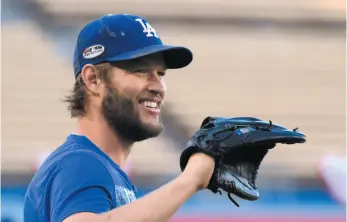  ?? AP PHOTO ?? Los Angeles Dodgers starting pitcher Clayton Kershaw smiles during a workout session in advance of the NLCS, which starts tonight in Milwaukee against the host Brewers.