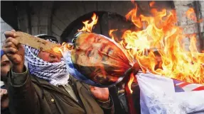  ??  ?? Fury: Palestinia­ns burn an effigy of Trump in the city of Nablus