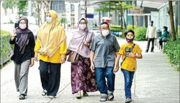  ?? AFP ?? Pedestrian­s wearing facemasks walk on a street in Kuala Lumpur on Tuesday.