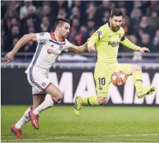  ?? — AFP ?? Barcelona’s Lionel Messi (R) controls the ball next to Lyon’s Leo Dubois during the Uefa Champions League round of 16 first leg match at the Groupama Stadium in Decines-charpieu, central-eastern France.