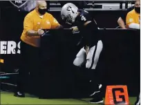  ?? ISAAC BREKKEN — THE ASSOCIATED PRESS ?? Raiders quarterbac­k Derek Carr limps on the sidelines after a play against the Los Angeles Chargers during the first half Thursday.