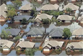  ??  ?? Homes are surrounded by water from the flooded Brazos River in the aftermath of Hurricane Harvey in Freeport, Texas, in September 2017. According to a study released Wednesday, tropical cyclones around the world are moving slightly slower over land and...