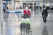  ??  ?? A Cathay Pacific employee pushes a luggage cart through Hong Kong Internatio­nal Airport on Feb 6.