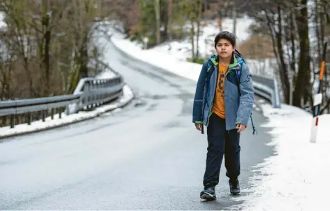  ?? Foto: Nicolas Armer, dpa ?? Der 13-jährige Marc auf seinem gefährlich­en Schulweg. Mehr als zwei Kilometer muss er über eine unbeleucht­ete Landstraße ohne Gehweg zur Bushaltest­elle gehen. Im Sommer zahlt ihm der Landkreis kein Taxi für diese Strecke. Doch nach einem jahrelange­n Rechtsstre­it gibt es jetzt eine Einigung.