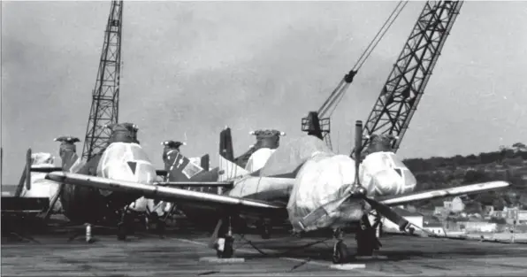  ?? DR ?? Sur le pont du porte-avions Dixmude, désormais navire de transport, le “Nomad” (N79Z) en compagnie d’hélicoptèr­es Vertol H-21C, des appareils destinés à rejoindre l’Algérie.Insigne de la 2e Escadrille de l’EALA 3/9.