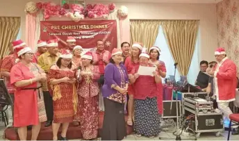  ?? ?? Sadia Kuching members render a Christmas carol with Sila (right) as master of ceremony during the dinner.