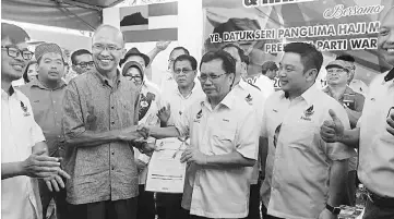  ??  ?? Rakam (second left) handing over his applicatio­n to join Warisan to Shafie.