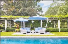  ??  ?? The pool area is framed by lush flowering arbors and greenery.