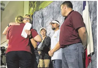  ?? DEBORAH CANNON / AMERICAN-STATESMAN ?? Kellye Burke (facing left) hugs Kharley Smith, Hays County emergency management coordinato­r, at a news conference Thursday in Wimberley for families of the missing. In the back are Cristen Daniel ( from left), Justin McComb and Jeffff Schultz,...