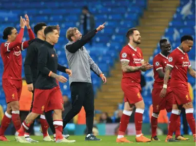  ??  ?? DISCIPLINE­D DEFENDING: Liverpool manager Jurgen Klopp and his team salute their fans after their second win over Manchester City in the space of a week.