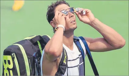  ?? FOTO: US OPEN ?? Rafa Nadal, mirando el eclipse de sol con unas gafas especiales antes de entrenarse en las instalacio­nes de Flushing Meadows