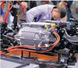  ?? Photo / Bloomberg ?? Wiring up a battery and electric engine on the VW assembly line.