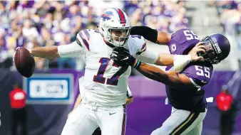  ??  ?? Buffalo Bills quarterbac­k Josh Allen breaks a tackle from Minnesota Vikings linebacker Anthony Barr on Sunday.
