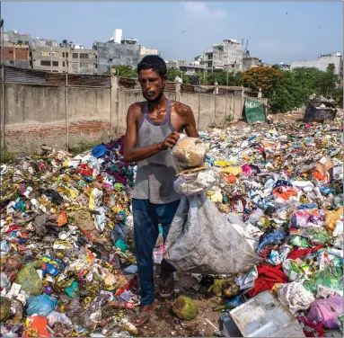  ??  ?? An Indian ragpicker collects valuable items from a dumping site in New Delhi, India. Health experts have warned that India may face further Covid-19 challenges if urgent steps are not taken for the proper disposal of masks, gloves and personal protective equipment