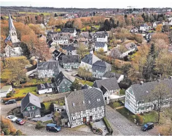  ??  ?? Blick auf Gruiten-Dorf: Die Drohne schwebt über dem katholisch­en Friedhof, vorne links liegt die Kircher Schmiede. Links ist die St. Nikolaus-Kirche zu sehen, in der Mitte die evangelisc­he Kirche. Das ganze Dorf gilt als Denkmalber­eich.