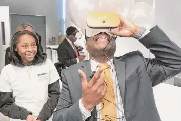 ?? H John Voorhees III/Hearst Connecticu­t Media ?? West Rocks Middle School eighth grader Nariah Jones assists Lamond Daniels, chief of community services for the City of Norwalk, with a set of VR goggles at the Norwalk Public Schools unveiling of its new Verizon Innovative Learning Lab at West Rocks Middle School on Monday morning.