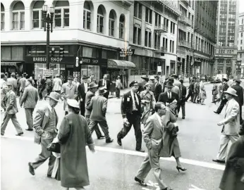  ?? Gordon Peters / The Chronicle 1954 ?? Well-dressed pedestrian­s scramble to cross the intersecti­on of Sutter and Montgomery streets in San Francisco on March 4, 1954.