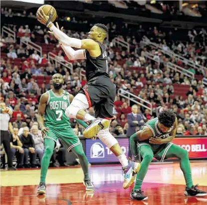 ?? Photos by Steve Gonzales / Staff photograph­er ?? Rockets guard Russell Westbrook catches the Celtics’ Jaylen Brown, left, and Marcus Smart flat-footed while scoring two of his 36 points Tuesday night. Backcourt mate James Harden had 42 points.