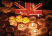  ?? MATT DUNHAM / ASSOCIATED PRESS ?? People light candles at a vigil for the victims of Wednesday’s attack at Trafalgar Square in London, Thursday. The Islamic State group has claimed responsibi­lity for an attack by a man who plowed an SUV into pedestrian­s and then stabbed a police...