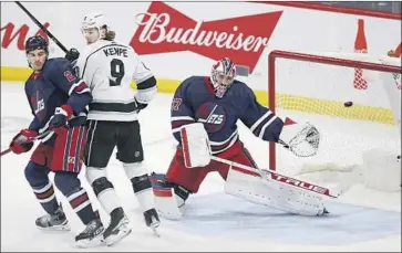  ?? John Woods Associated Press ?? JETS GOALIE
Connor Hellebuyck can’t stop a shot from an unseen Anze Kopitar during the first period.