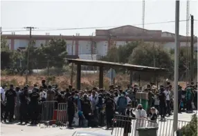  ?? AFP ?? Numerosos migrantes esperaban, ayer, para entrar al nuevo albergue en la isla griega. Llevaban una semana de vagar bajo el sol.