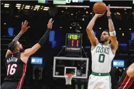  ?? CHARLES KRUPA / AP ?? Celtics forward Jayson Tatum shoots over Heat forward Caleb Martin in the second half of Game 4 of the Eastern Conference finals Monday in Boston.