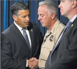  ?? Erik Verduzco ?? Las Vegas Review-journal Gov. Brian Sandoval, left, and Clark County County Sheriff Joe Lombardo shake hands during a press conference Monday at the Las Vegas Metropolit­an Police Department headquarte­rs on Sunday’s mass shooting on the Strip.