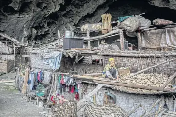  ??  ?? BUSTLING VILLAGE: A resident of the Zhong cave collects dried corn cobs from the roof of her family’s home.