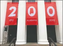  ??  ?? A worker adjusts a banner celebratin­g Alabama’s bicentenni­al outside the Department of Archives and History.