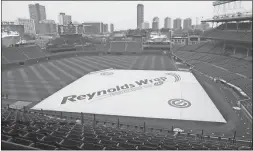  ?? Matt Marton / The Associated Press ?? A tarp covers Wrigley Field after rain postponed Saturday’s game between the Chicago Cubs and the Atlanta Braves in Chicago. The series between the two teams will conclude today. No makeup date was immediatel­y announced.