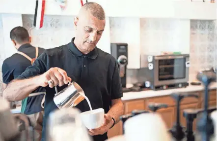  ?? PHOTOS BY COURTNEY HERGESHEIM­ER/COLUMBUS DISPATCH ?? Abdul Nagi, co owner of Qamaria Yemeni Coffee Co. in Hilliard, makes a latte on May 19. Yemen is said to be the birthplace of coffee.