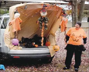  ?? Westside Eagle Observer/MIKE ECKELS ?? A vendor waits by an elaboratel­y decorated rear compartmen­t of an SUV Saturday night at Veterans Park in Decatur. This vendor joined over a dozen others during the Second Annual Decatur Trunk or Treat Halloween Giveaway.