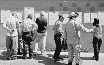  ??  ?? People check electoral lists at a polling station during the municipal legislator­s election in Caracas,Venezuela. — Reuters photo