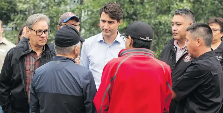  ?? — THE CANADIAN PRESS ?? Prime Minister Justin Trudeau listens to First Nations members along with Grand Chief Ed John, back left, in Prince George on Thursday.