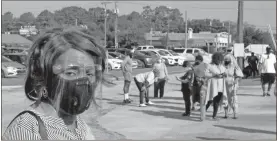  ?? Ap-russ Bynum, File ?? Khani Morgan, wearing a mask and face shield to guard against the coronaviru­s, waits in line to vote early on Wednesday in Savannah. Morgan says her great-grandmothe­r who was born a slave talked about the importance of voting, so “I won’t let anything get in the way of me and this opportunit­y.”