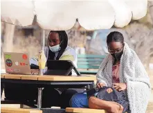  ??  ?? Kenya native Rita Menja, left, now of Edmond, Okla., and Nigerian native Ajanigo “Jani” Anya Amaka Wodi, now of Marietta, Ga., take advantage of the mild weather to study outside at the United World College-USA.