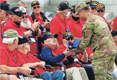  ?? PHOTOS BY NICOLAS GALINDO/COLUMBUS DISPATCH ?? World War II Navy veteran William Jackson is presented a folded flag from Army staff Sergeant Tyler Goodwin at the World War II memorial in Washington, D.C., during Honor Flight Columbus Mission #104 on Thursday. Honor Flights began in 2005 to bring surviving World War II veterans to Washington to visit the World War II memorial after it was completed in 2004.