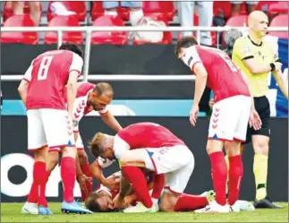  ?? AFP ?? Denmark players help midfielder Christian Eriksen after he collapsed before medics arrive during the UEFA EURO 2020 Group B football match on Saturday.