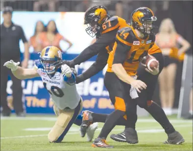  ?? The Canadian Press ?? B.C. Lions quarterbac­k Travis Lulay, right, runs the ball for a touchdown as Hunter Steward (67) blocks Winnipeg Blue Bombers’ Sam Hurl (10) during second-half CFL action at B.C. Place Stadium in Vancouver on Friday. The Lions won 45-42.