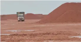  ?? — AFP ?? This picture taken in Kendawanga­n, West Kalimantan on Borneo island shows a truck carrying material next to piles of bauxite materials at a mining belonging to Harita group in Kendawanga­n.