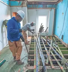  ?? DOUG KAPUSTIN FOR USA TODAY ?? Orlando Simmons, left, and Damon Toogood remove planks of flooring from an abandoned row home in Baltimore.