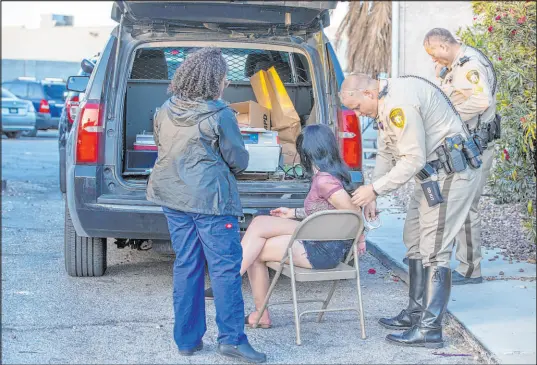  ?? L.E. Baskow Las Vegas Review-journal @Left_eye_images ?? Metro officer Garrett Jones uncuffs Camryn Hailee Grant as phlebotomi­st Ashley Webber-gamboa, left, readies to take a blood sample during a DUI blitz in April. During the blitz operations, Webber-gamboa said she can make almost 20 blood draws.