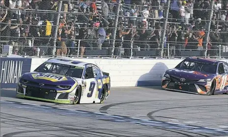  ?? Nick Wass/Associated Press ?? Chase Elliott, front, beats Denny Hamlin to the checkered flag to win the NASCAR Cup Series race Sunday at Dover Internatio­nal Speedway in Dover, Del.