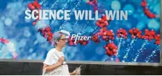  ?? Foto: Niyi Fote, dpa ?? Eine Frau geht in New York an einem Werbeplaka­t des Unternehme­ns Pfizer vorbei. Der Impfstoff von Biontech‰Pfizer ist jetzt vollständi­g zugelassen.
