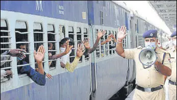  ?? BHARAT BHUSHAN/HT ?? Migrants wave at cops as they leave in a Shramik Special train for Bihar from the Patiala railway station on Wednesday.