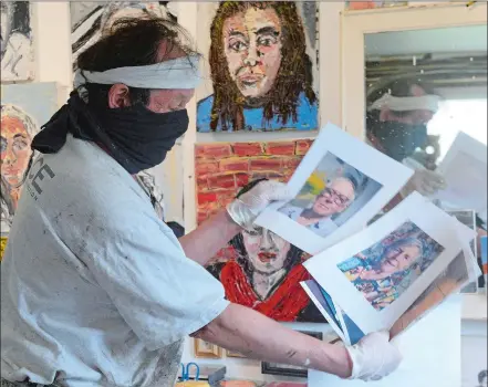  ?? DANA JENSEN/THE DAY ?? R. Douglass Rice, in his Stonington studio, shows a few of the selfie photos that he has received for his new project. Rice asked people to send him selfies and is painting their portraits and calling the project “Portraits of Friends in Isolation.” On the wall in the background are a few of the portraits he has painted.