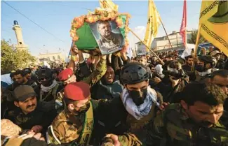  ?? AHMED AL-RUBAYE/GETTY-AFP ?? Members of Iraq’s Hashed al-Shaabi (Popular Mobilisati­on) carry the coffin of Abu Baqir al-Saadi, a prominent leader who was killed in a U.S. airstrike, during his funeral Thursday in Baghdad.