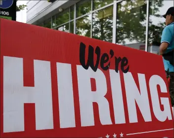  ?? OLIVIER DOULIERY — GETTY IMAGES/TNS ?? A man walks past a “now hiring” sign posted outside of a restaurant in Arlington, Virginia on June 3. Job growth is one of the factors economists weigh in determinin­g whether the economy is in recession.