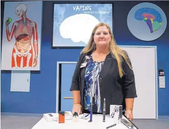  ?? JUNFU HAN/DETROIT FREE PRESS ?? Cheryl Phillips, coordinato­r for St. Joseph Mercy Health Exploratio­n Station, poses for a photo with a display of popular vaping products that she uses for her presentati­on.