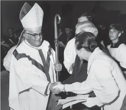  ?? THE COMMERCIAL APPEAL ?? Bishop Carroll T. Dozier of the Catholic Diocese of Memphis shakes hands with Dr. and Mrs. David Taylor during a procession­al on May 21, 1971.